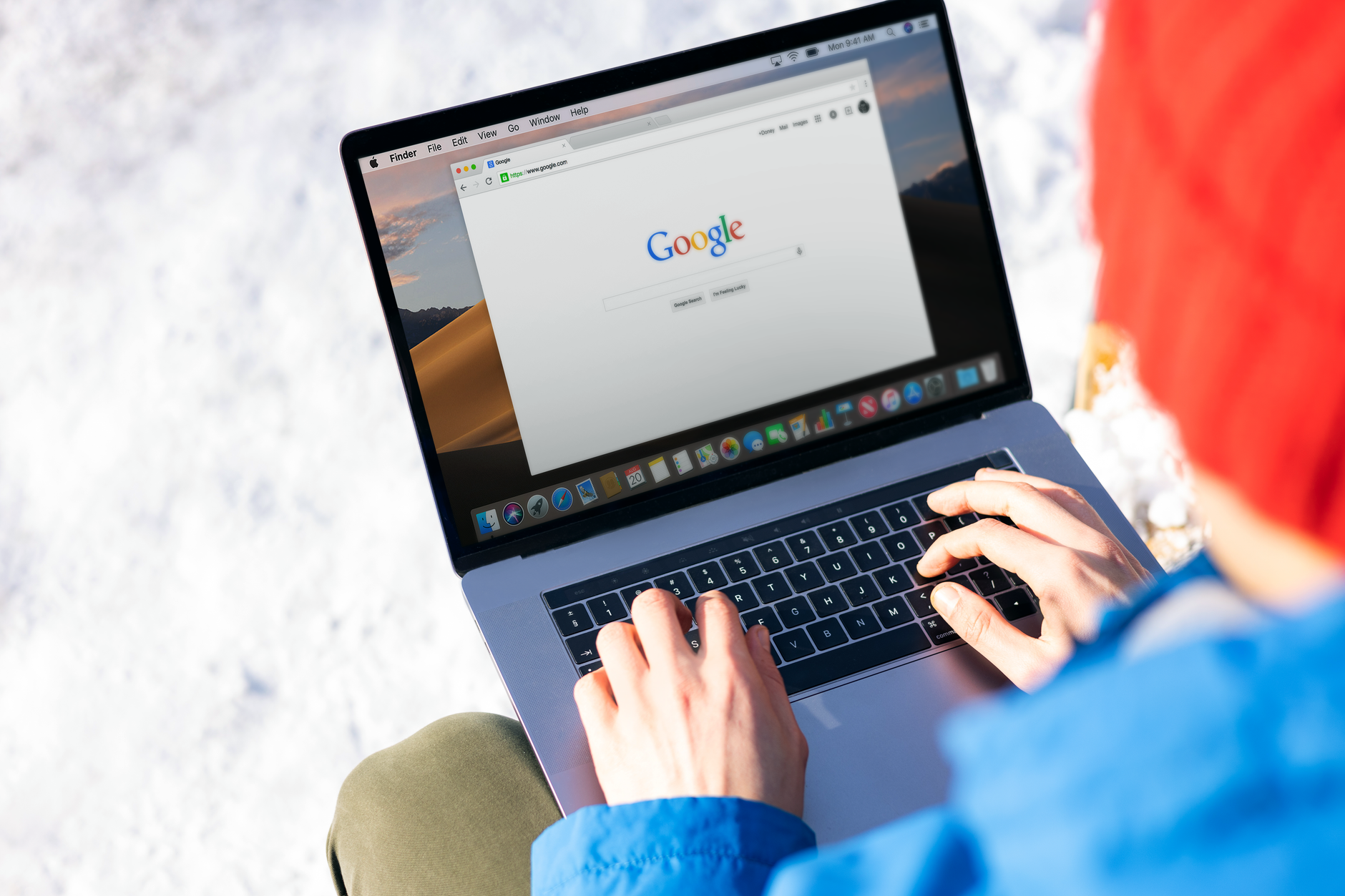 A person types on a laptop while checking an official scam reporting website.